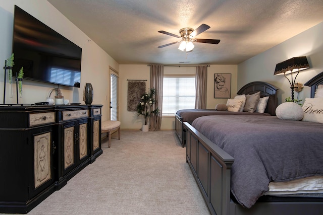 carpeted bedroom featuring ceiling fan and a textured ceiling