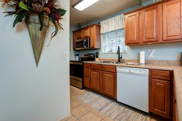 kitchen featuring light tile patterned floors, sink, and appliances with stainless steel finishes