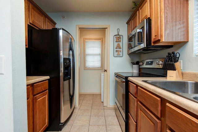 kitchen with appliances with stainless steel finishes and light tile patterned flooring