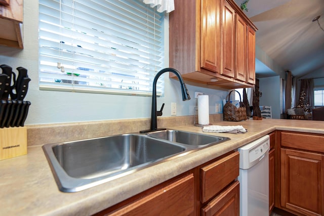 kitchen featuring vaulted ceiling, sink, and white dishwasher