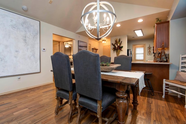 dining space featuring vaulted ceiling, dark wood-type flooring, and a notable chandelier