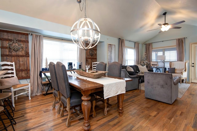 dining room featuring lofted ceiling, ceiling fan with notable chandelier, and hardwood / wood-style floors