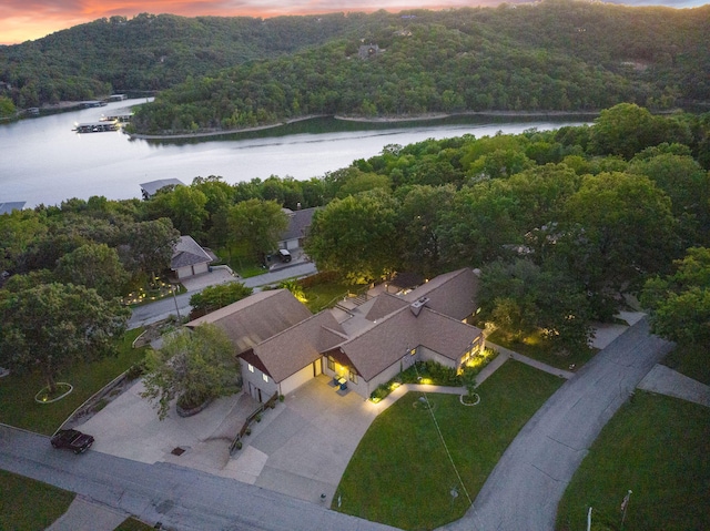 aerial view at dusk with a forest view and a water view