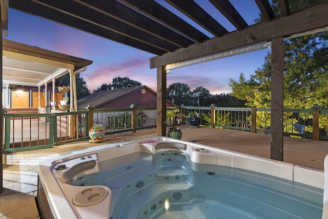 pool at dusk featuring a wooden deck and an outdoor hot tub