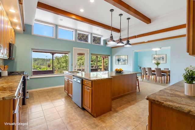 kitchen featuring stainless steel appliances, a kitchen island with sink, hanging light fixtures, light stone counters, and sink