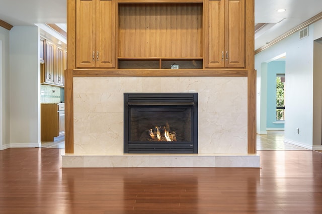 room details with wood-type flooring, backsplash, and crown molding