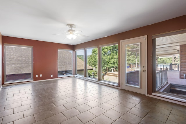 tiled spare room featuring ceiling fan and a wealth of natural light