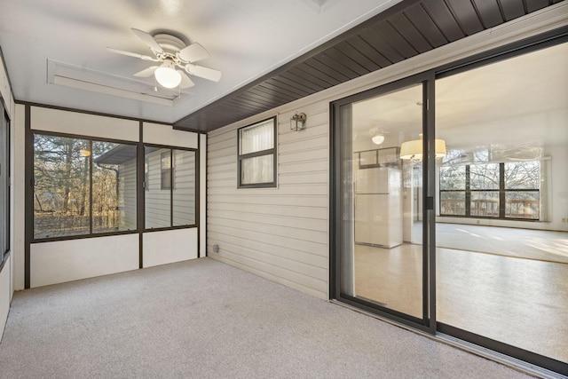 unfurnished sunroom featuring ceiling fan