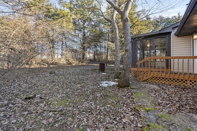 view of yard featuring a wooden deck and a sunroom