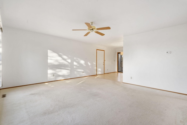 carpeted spare room featuring ceiling fan