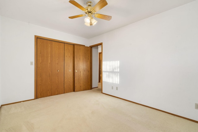 unfurnished bedroom featuring ceiling fan, a closet, and light carpet