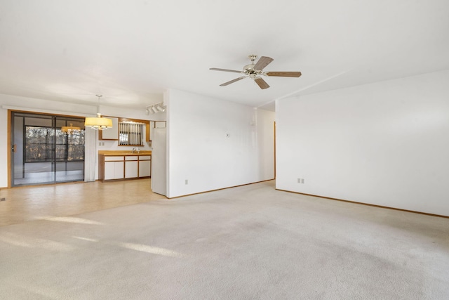 unfurnished living room featuring ceiling fan and carpet floors