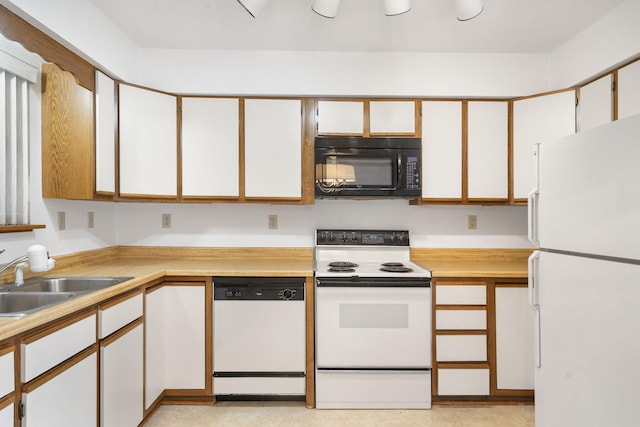 kitchen featuring white cabinetry, sink, and white appliances