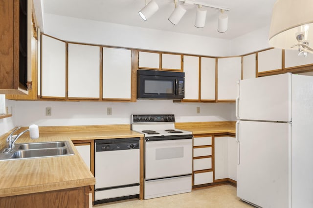 kitchen with sink, white appliances, and white cabinets