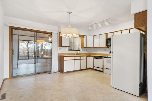 kitchen featuring pendant lighting, white appliances, white cabinets, and an inviting chandelier