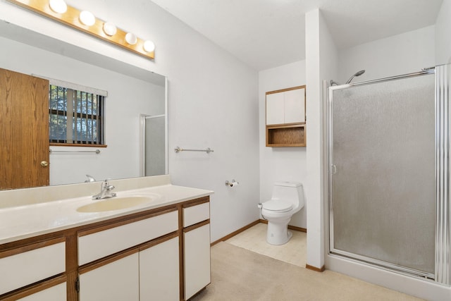 bathroom featuring vanity, toilet, and a shower with door