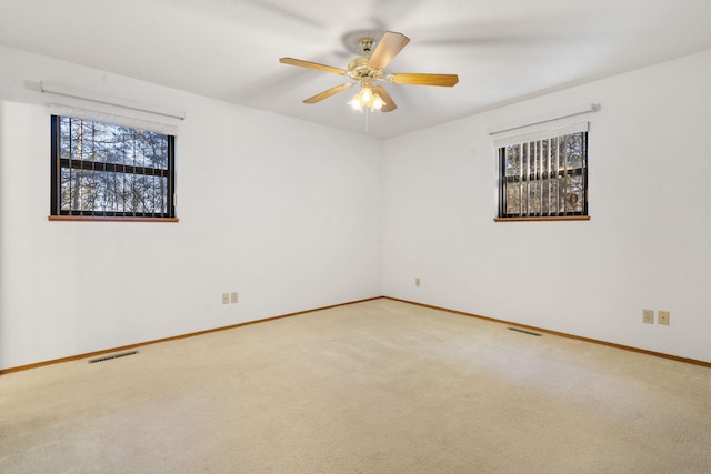 carpeted spare room with ceiling fan