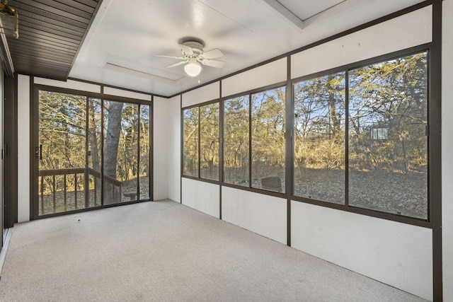 unfurnished sunroom featuring ceiling fan and a healthy amount of sunlight