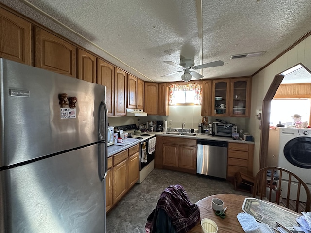 kitchen featuring washer / dryer, stainless steel appliances, sink, ceiling fan, and crown molding