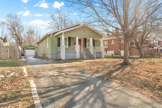 view of front of home featuring a garage, an outbuilding, and a porch