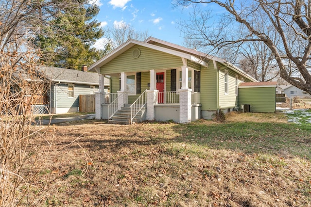 bungalow-style home featuring a front yard, a porch, and central air condition unit