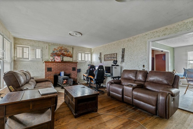 living room featuring a textured ceiling, a wood stove, and hardwood / wood-style floors