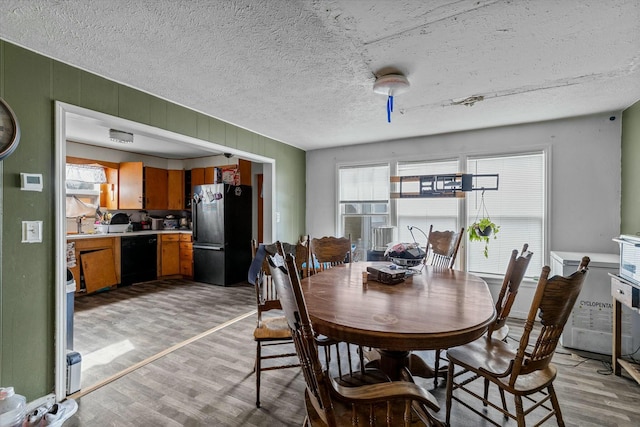 dining area featuring wooden walls and light wood-type flooring