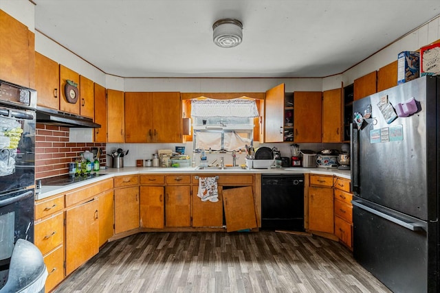 kitchen with decorative backsplash, sink, black appliances, and dark wood-type flooring