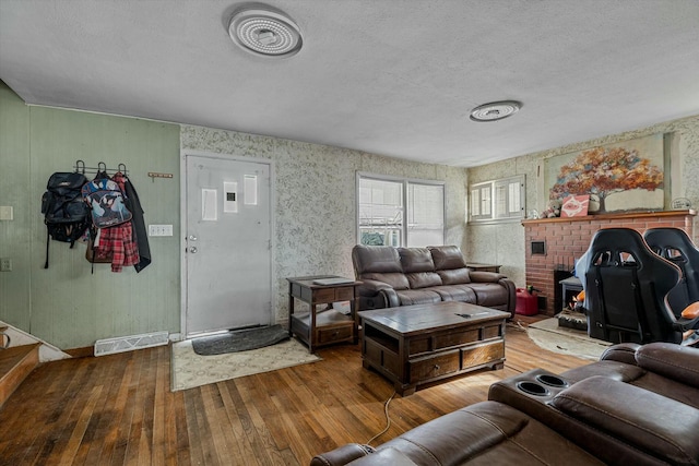 living room with wood-type flooring and a textured ceiling