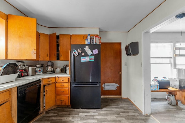 kitchen with black appliances, backsplash, and hardwood / wood-style floors