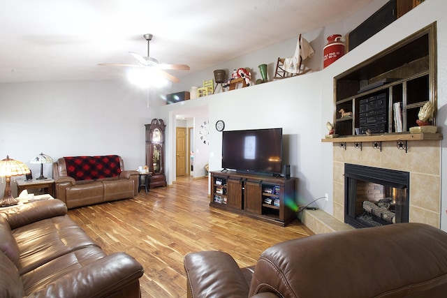 living room with ceiling fan, built in features, a fireplace, and hardwood / wood-style flooring