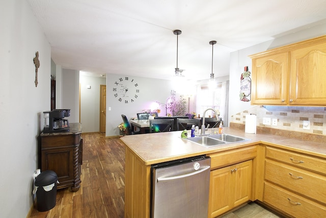 kitchen with decorative light fixtures, dishwasher, kitchen peninsula, and sink