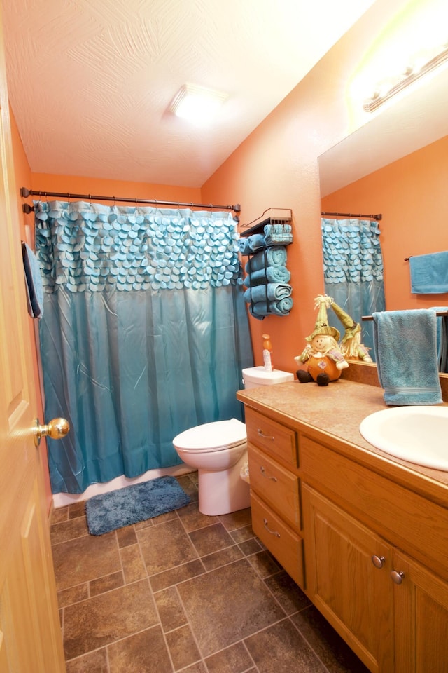 bathroom featuring toilet, vanity, and a shower with shower curtain