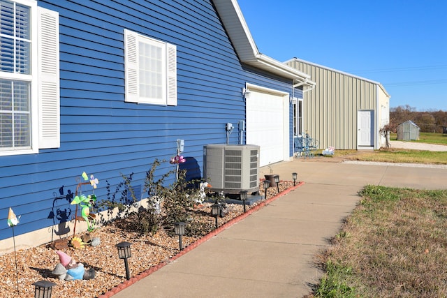 view of side of home featuring a garage and central AC