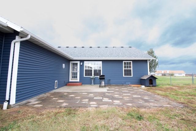 rear view of property with a lawn and a patio