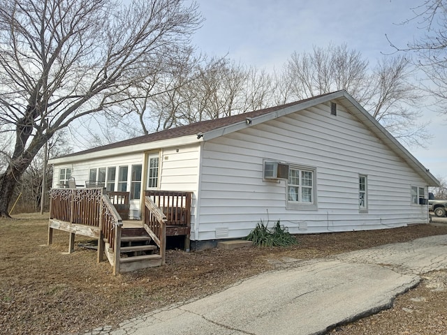 rear view of house with a deck and a wall mounted AC