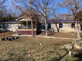 rear view of property featuring a lawn