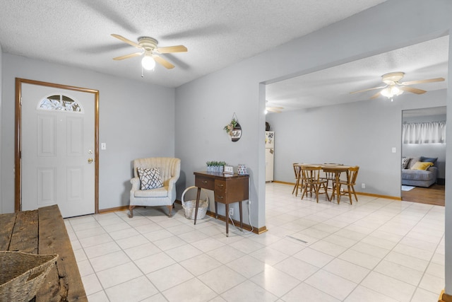 entrance foyer featuring ceiling fan and a textured ceiling