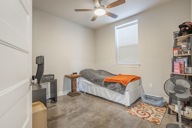 bedroom featuring a ceiling fan, concrete floors, and baseboards