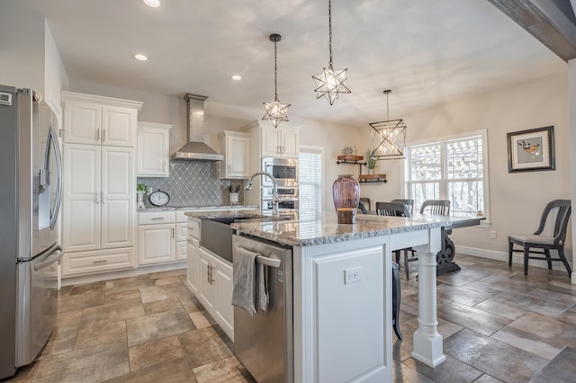 kitchen with a kitchen bar, a sink, stainless steel appliances, wall chimney range hood, and decorative backsplash