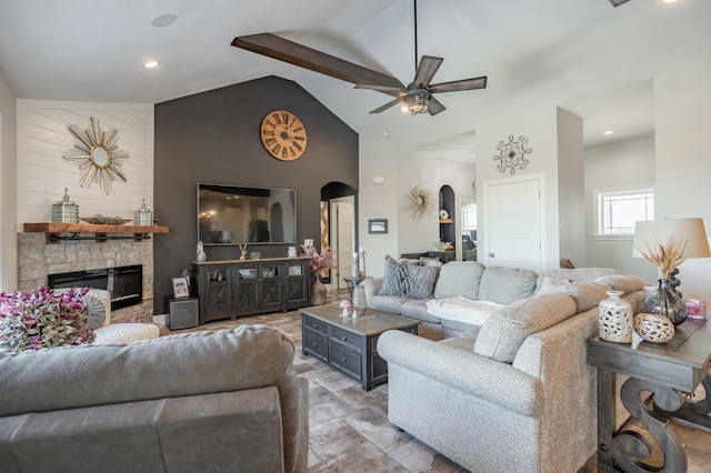 living area featuring arched walkways, a fireplace, high vaulted ceiling, and ceiling fan