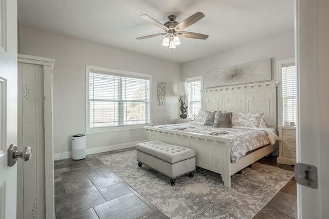 bedroom with a ceiling fan and baseboards