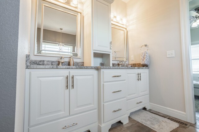 full bath with baseboards and double vanity