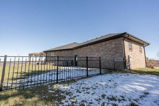 view of property exterior featuring brick siding and fence