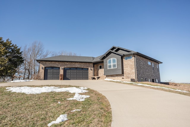 view of front of property featuring brick siding, an attached garage, and driveway