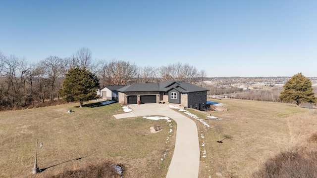 view of front of home with concrete driveway, brick siding, a garage, and a front yard