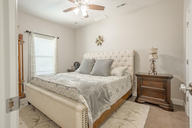 carpeted bedroom with visible vents, baseboards, and ceiling fan