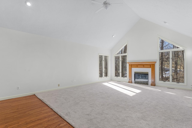 unfurnished living room with ceiling fan and high vaulted ceiling