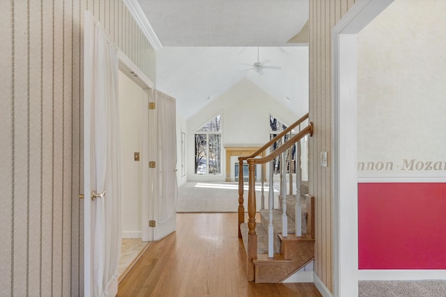 hall with wood-type flooring and vaulted ceiling