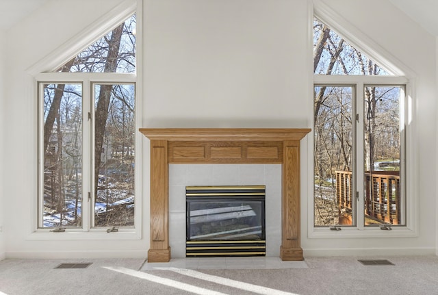 interior details with carpet flooring and a tile fireplace